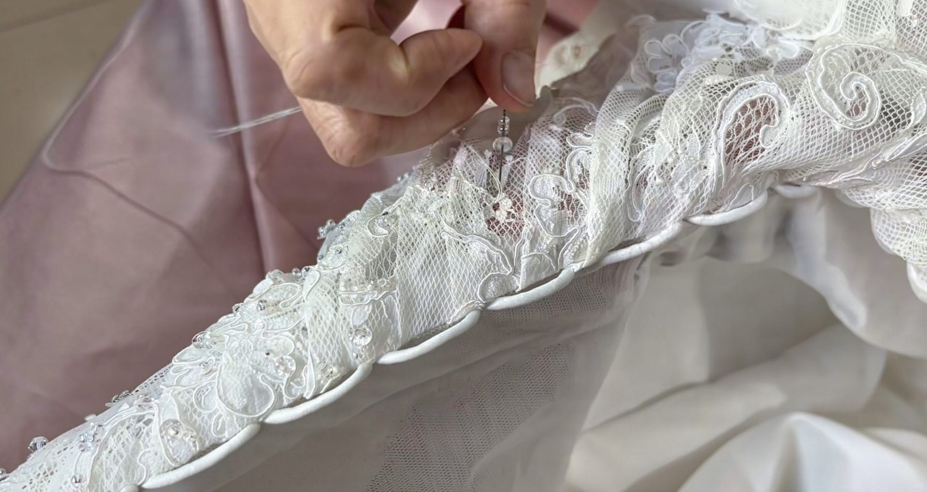 Small hand sewn beadwork following floral motifs on an eyelash lace bridal gown
