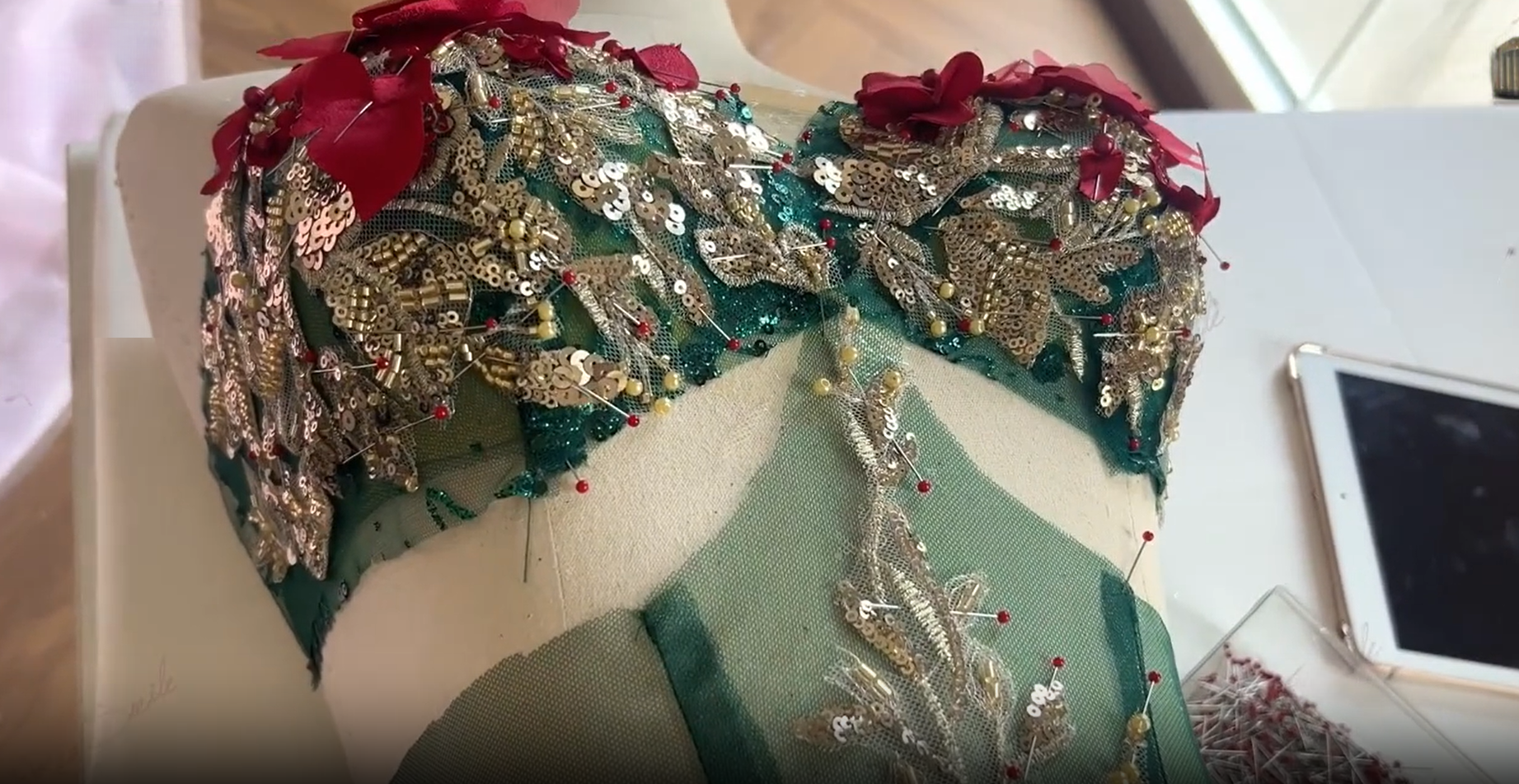 Tailor pinning details on green corset bodice