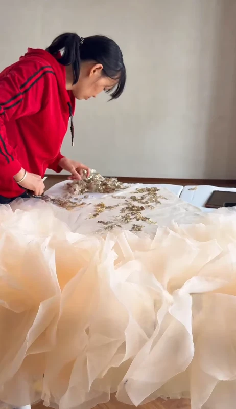Working on the champagne tulle skirt during gown construction Working on the champagne tulle skirt during gown construction