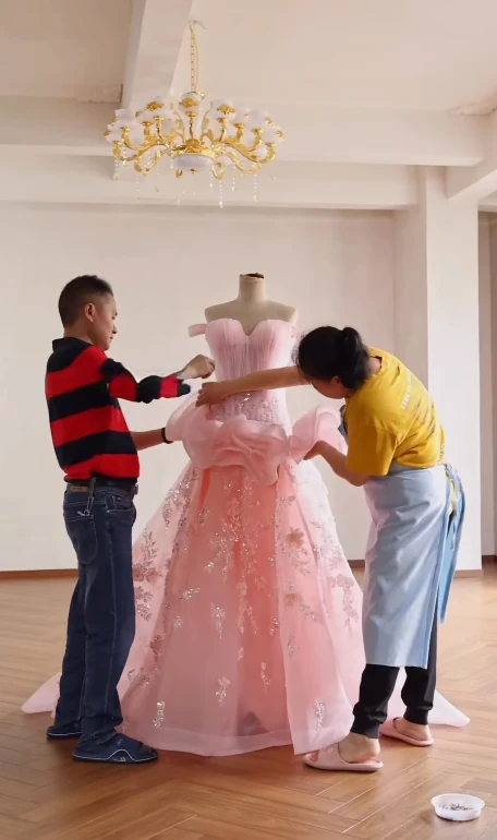 Workshop team building ruffle layers for a floral pink couture ball gown