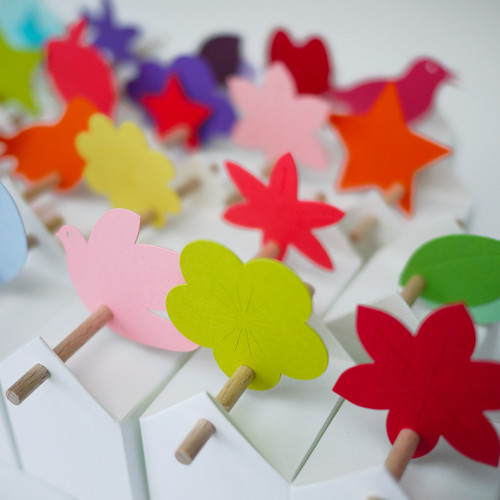 boîtes à dragées avec étiquettes aux formes et aux couleurs variées, assortiment joyeux (fleurs, feuilles, oiseaux, pommes, nuages, étoiles), option dragées amande blanches et dragées chocolat assorties