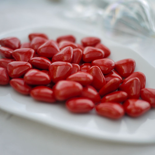 dragées au chocolat (70%) en forme stylisée de coeur; couleur rouge, vernis