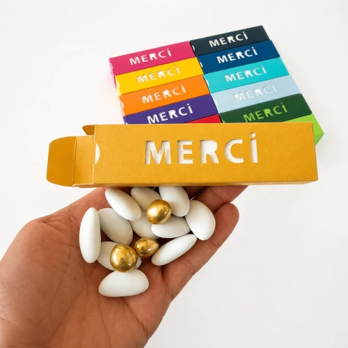 Boîte Merci tenue dans la main avec confiseries fines