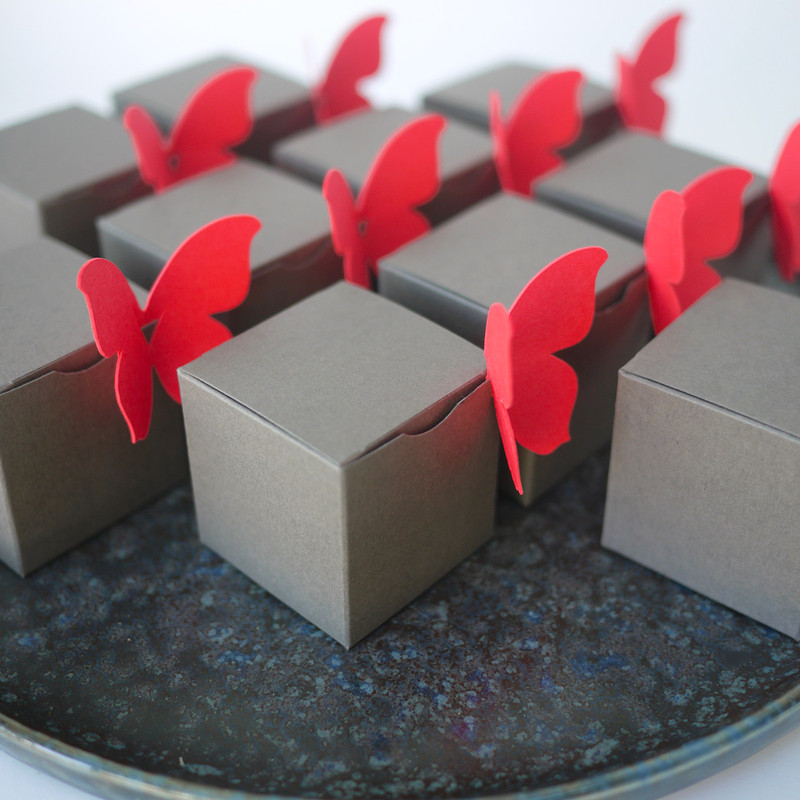 Boîte à dragées toute simple, cube couleur gris taupe, et ici un papillon corail
