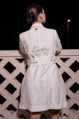 Kashesh Ruhee Coat: A cream and gold handwoven mid-length trench coat featuring a statement lapel, luxurious red silk lining, and a belt with 'Dream' sequined detailing