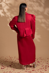 Kashesh Global Pataka Ensemble: A striking scarlet red overlap dress in a linen-satin blend, worn with a structured puff-sleeve statement jacket featuring genuine rose quartz hand-embroidery