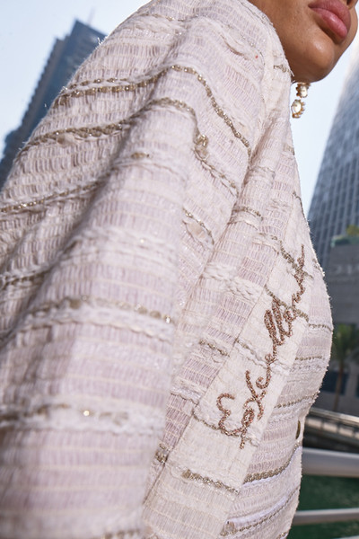 Kashesh Haadiya Coat in Ivory: Women's handwoven long jacket made from recycled fabrics, featuring 'Excellence' sequin trim and a red silk lining