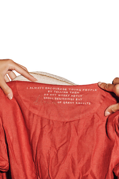 Kashesh Ruhee Coat: A cream and gold handwoven mid-length trench coat featuring a statement lapel, luxurious red silk lining, and a belt with 'Dream' sequined detailing