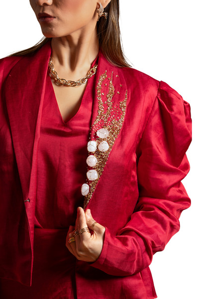 Kashesh Global Pataka Ensemble: A striking scarlet red overlap dress in a linen-satin blend, worn with a structured puff-sleeve statement jacket featuring genuine rose quartz hand-embroidery