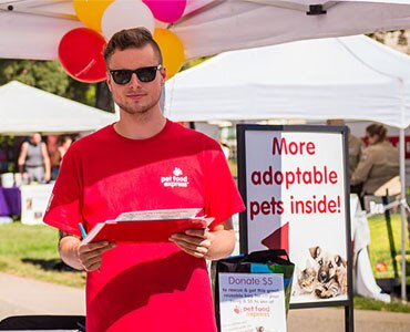 Pet Food Express employees in red shirts at Bay Area Pet Fair booth