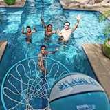 Family playing pool basketball with Splash It ball mid-air above hoop in modern T-shaped swimming pool