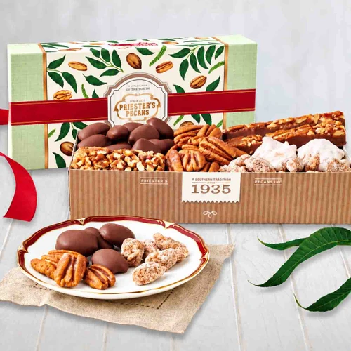 Priester’s Southern Delight Sampler Box with pecan divinity, Fiddlesticks, a pecan log roll, and assorted pecans in a pecan and leaf patterned gift box.