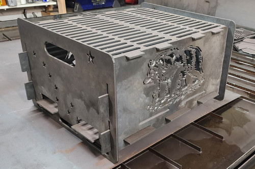 This Alaska-themed fire pit is proudly made in Alaska and crafted from 3/16 in. steel plate, featuring intricate cutout panels with wildlife and mountain scenery. Built to last and make a statement in any outdoor space.