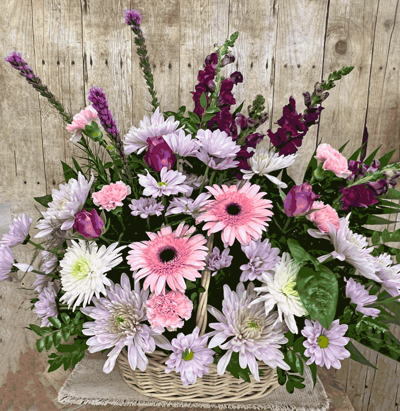 Sympathy funeral basket displayed next to a casket with fresh seasonal flowers for funeral and memorial services by Wendy's Flowers in Gilbertsville, PA.