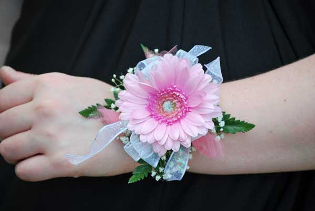 Bright gerber daisy wrist corsage with ribbon accents for prom