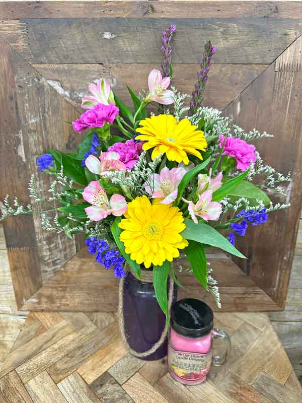 Bright Easter flower arrangement with yellow gerbera daisies pink carnations and candle gift set in vase