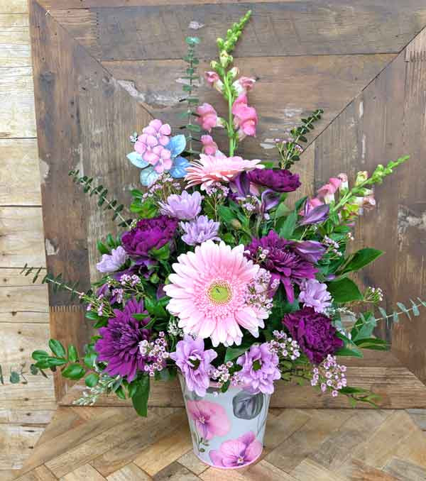 Luminous Petals Mother’s Day bouquet with pink and purple flowers in iridescent vase