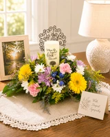 Beautiful remembrance LED candle nestled within a handcrafted sympathy flower arrangement displayed as a comforting memorial centerpiece for a funeral, celebration of life, or family home.