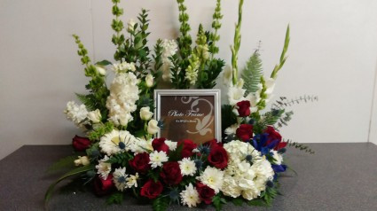 Custom floral wreath surrounding a picture frame at a memorial display