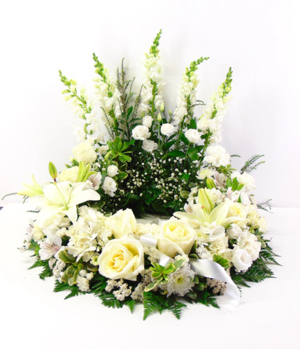 Funeral urn wreath centerpiece with hydrangeas, roses, and wildflowers in a memorial setting