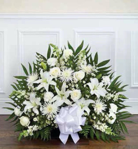 Elegant sympathy flower basket with seasonal blooms and greenery in a wicker container