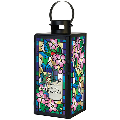 Stained glass memorial lantern with colorful butterfly artwork and sympathy flowers displayed in a home setting
