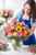 florist designing everyday flower arrangement with roses carnations and seasonal flowers in vase grande version
