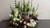 Custom floral wreath surrounding a picture frame at a memorial display