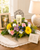 Beautiful remembrance LED candle nestled within a handcrafted sympathy flower arrangement displayed as a comforting memorial centerpiece for a funeral, celebration of life, or family home.