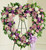Elegant sympathy heart wreath with pastel flowers displayed beside a casket at a funeral service
