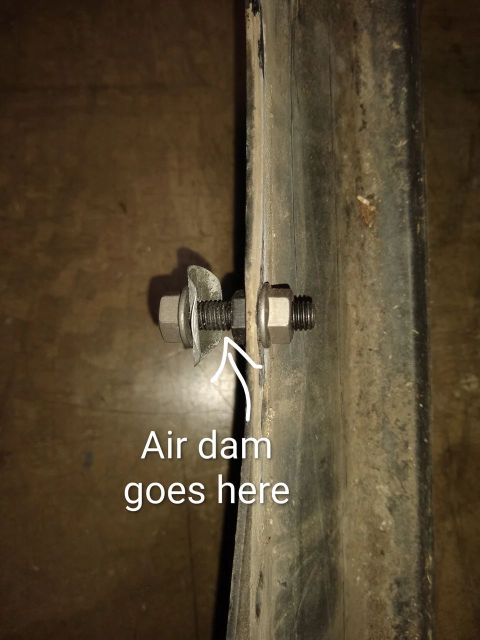 Air dam stud with flange nuts and spring steel washer assembled on bumper