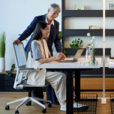 Frau sitzt auf einem weißen Ergonomischen Bürostuhl Active und spricht mit ihrem Vorgesetzten