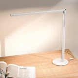 ofinto Tischlampe Lumino Desk Weiss mit Standfuß - LED-Schreibtischlampe auf Holztisch mit offener Zeitschrift, moderne minimalistische Arbeitsplatzbeleuchtung