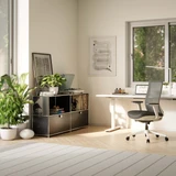 Cubox Sideboard mit 2 Ebenen und 2 Klappen in Schwarz mit Pflanzen und Büchern im hellen Homeoffice neben Schreibtisch und Bürostuhl