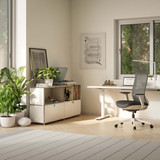 Cubox Sideboard mit 2 Ebenen und 2 Klappen in Weiß mit Pflanzen und Büchern im hellen Homeoffice neben Schreibtisch und Bürostuhl