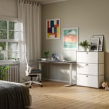 Cubox Büroregal mit 3 Ebenen und 3 Klappen in Weiß mit Pflanze und Bilderrahmen im hellen Homeoffice neben Schreibtisch und Bürostuhl