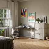 Cubox Büroregal mit 3 Ebenen und 3 Klappen in Seidengrau mit Pflanze und Bilderrahmen im hellen Homeoffice neben Schreibtisch und Bürostuhl