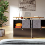 Cubox Sideboard mit Soft Panel Granitgrau, warmes Wohnzimmer mit orangem Sitzkissen und Vase