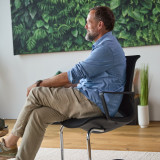 ofinto Flex Meeting Stuhl Seitenansicht - bequemer Sitzkomfort des Freischwingers mit ergonomischer Formgebung und stabilem Chrom-Gestell vor botanischem Wandbild