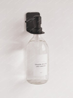 Distributeur de savon mural : flacon en verre transparent étiqueté Savon pour les mains, suspendu à un support noir fixé au mur
