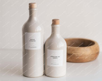 Deux bouteilles huilier en grès beige à bouchons en bois, étiquettes Huile d'olive et Vinaigre de Xérès, devant un bol en bois