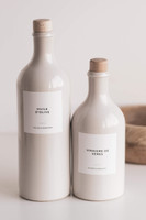 Deux bouteilles huilier en grès beige à bouchons en bois, en deux tailles, étiquettes Huile d'olive et Vinaigre de Xérès