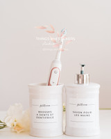 Pot à brosses à dents blanc avec brosse électrique et distributeur de savon assorti, étiquettes de salle de bain Bathroom, près de roses blanches