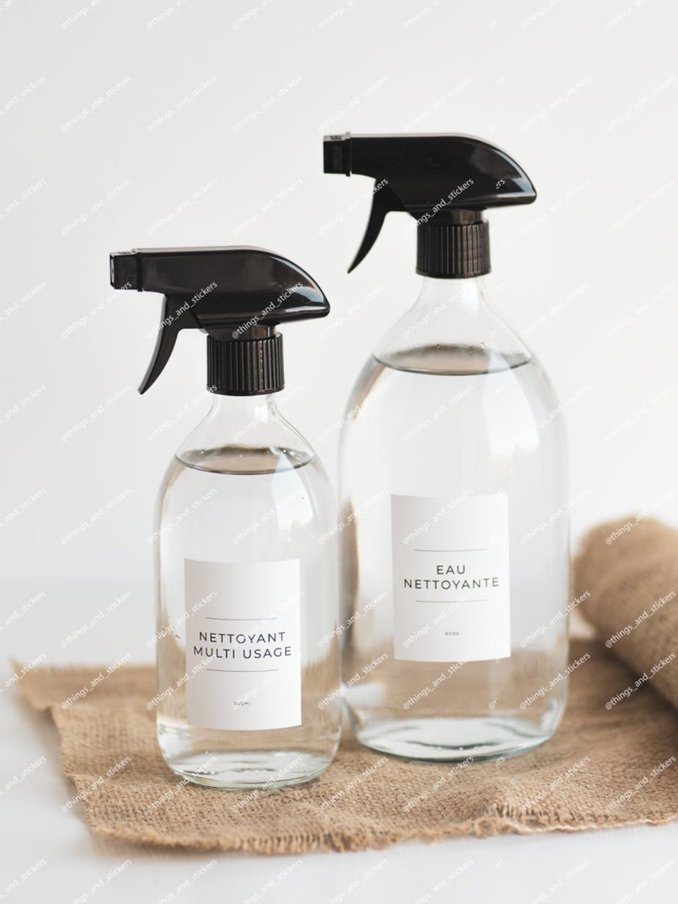 Deux sprays en verre transparent étiquetés, nettoyant multi-usage et eau nettoyante