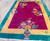 Angled, top facing image of antique Chinese carpet, showing a dimensional view of the rug in a room.