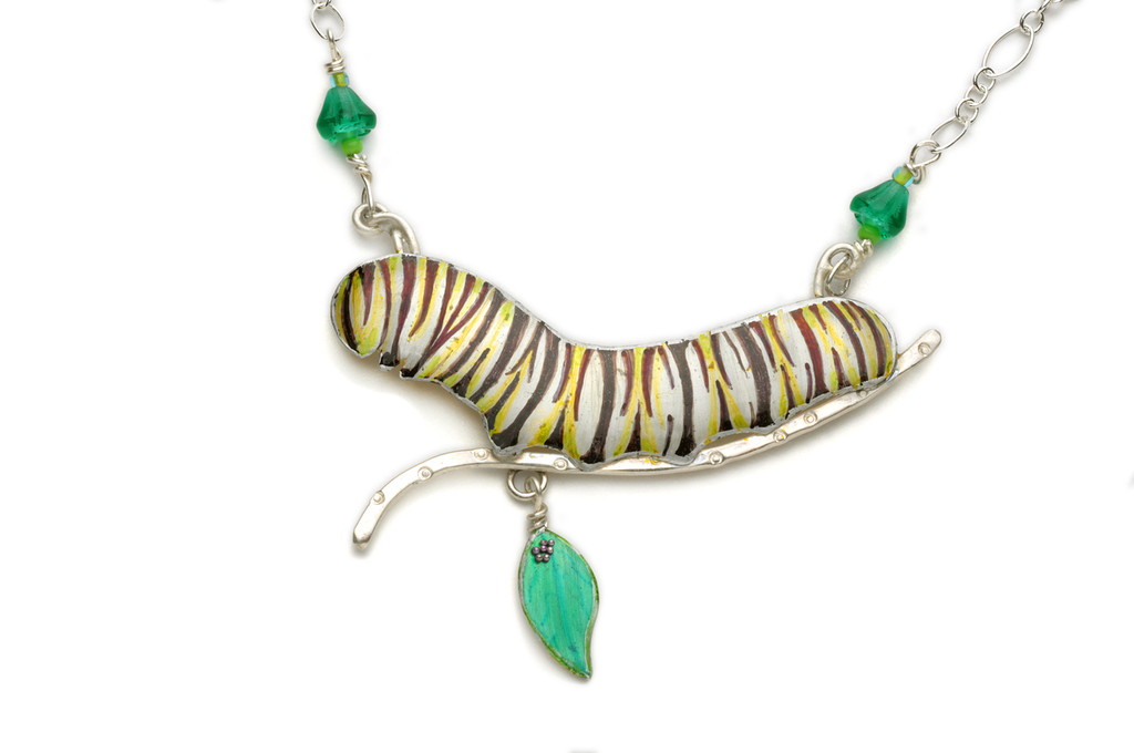 Because our world can use all the monarchs it can get, the Monarch Caterpillar Necklace has arrived. The monarch butterfly population has dropped significantly over the last ten years, but this year was more promising than any of the last five. What happened to help to turn around this icon of the natural world? No one knows for sure, but awareness of the issue is no doubt key. And wearing monarch-themed apparel, either in butterfly or caterpillar form, helps to raise this awareness. And then there is the fact that both stages of this butterfly are beautiful and fun to wear. This necklace is 18" long. The caterpillar itself, along with its supportive stick, is 2.5" long 1.75 tall, including the dangling milkweed leaf. The chain is Sterling Silver, and the caterpillar is lacquered and painted brass, along with Sterling embellishments. I have carefully painted the caterpillar, and the protected it with various protective clear coats, topping it with a bullet-proof, shimmery resin coat. This necklace is the ultimate tribute to monarch butterflies.