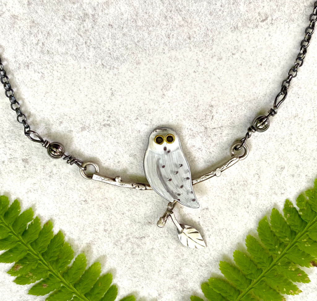 Snowy Owls are a remarkable bird, living in arctic conditions for much of the year. These earrings are in honor of their fortitude and beauty. They are handmade out of Sterling and jeweler's brass. The 2" focal point features an owl perched on a carved Sterling branch which is suspended from an oxidized Sterling chain. The total length of the necklace is 18" long.
