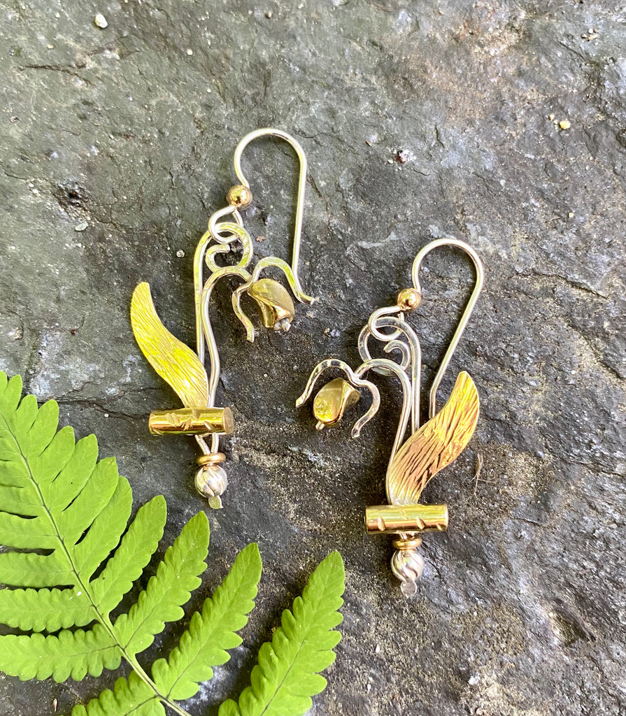 Seeing a lady's slipper blooming in the woods is always a thrill. Wearing a pair of these woodland orchids pays tribute to their beauty. These earrings are handcrafted from Sterling silver and lacquered jeweler's brass, and sport Sterling pierced earring wires. Non-pierced clips may be substituted by request. They come in a gift box.  The size is 1/2" x 1 3/8".