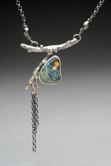 This necklace features a lovely piece of Stone Stack Slag that I found in the Gale River in Franconia. It could have come from anywhere that had an iron industry 200 years ago (and you would be surprised by just how many locations there are!). I polished this piece, and added a bit of gold mica powder melange, borrowing the Japanese concept of kintsugi, celebrating the broken. I then set it on a oxidized Sterling branch that I fabricated, and dangled small lengths of Sterling chain. They suggest spring flowering tree blooms. The necklace is 18" long, and brings together the beauty of nature with the fascination of local history and those who came before us. 
