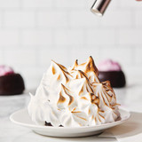 complete baked alaska with bakers torch browning the meringue